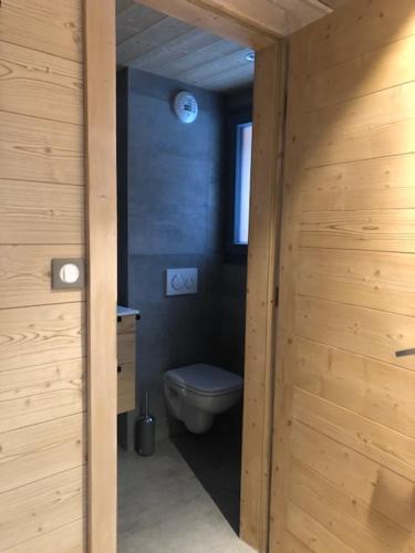 a bathroom with a toilet and a wooden wall at Chalet Croq'Neige in Morzine