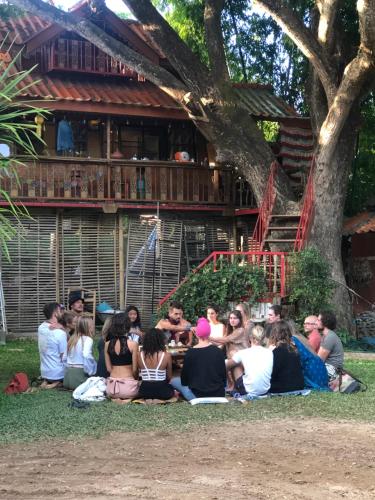 a group of people sitting on the grass in front of a house at Good Life Dacha Wellness Homestay in Pai