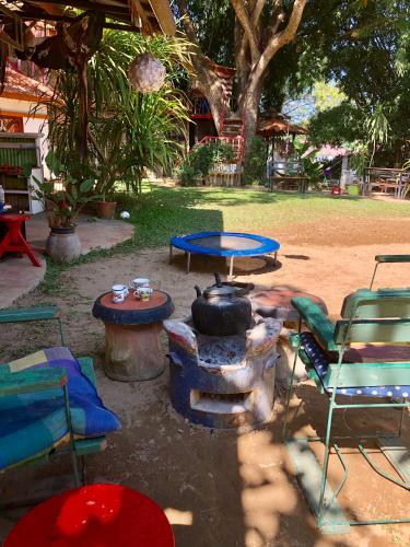 a patio with a table and chairs and a fire pit at Good Life Dacha Wellness Homestay in Pai