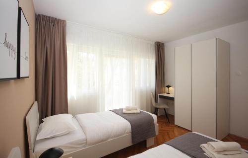 niewielka sypialnia z 2 łóżkami i biurkiem w obiekcie Apartman Nonno w Puli