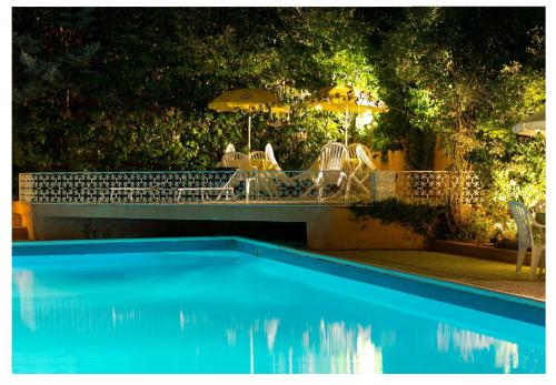 a swimming pool with chairs and umbrellas in a yard at Nuovo Mondo in Montefalco