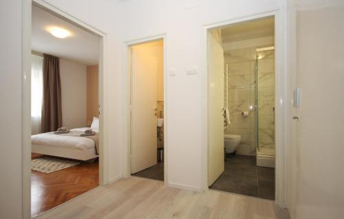 um quarto com uma cama e uma casa de banho com um chuveiro em Apartman Nonno em Pula