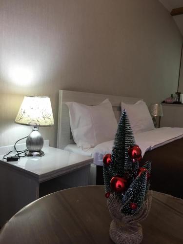 a room with a table with a christmas tree on a bed at Jorjadze street 23 in Borjomi