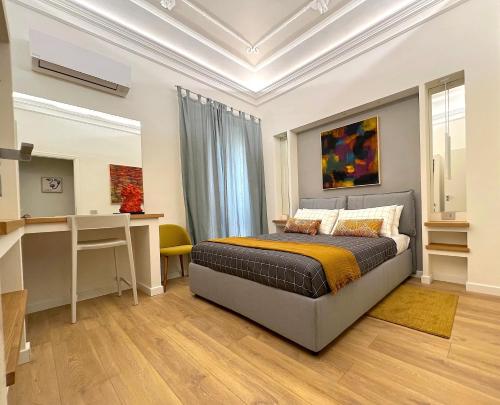 a bedroom with a bed and a desk at ERASMO 19 Luxury Home in Catania