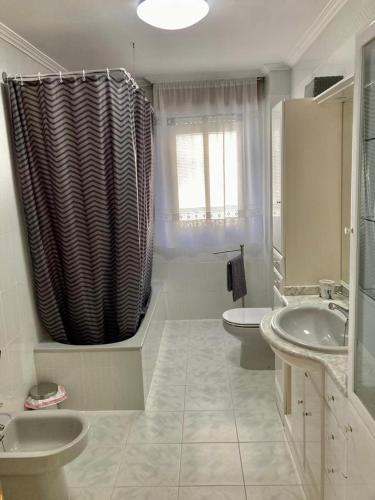 a bathroom with two sinks and a shower curtain at CASA RURAL COSTALAGO in Hontoria del Pinar