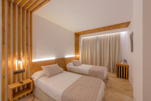 a hotel room with two beds and a window at Hotel Boutique Sibarys - Adults Recommended in Nerja