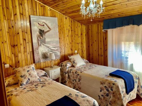 a bedroom with two beds and a painting on the wall at CASA RURAL COSTALAGO in Hontoria del Pinar