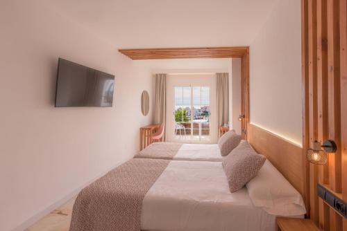 a bedroom with a bed with a television on the wall at Hotel Boutique Sibarys - Adults Recommended in Nerja