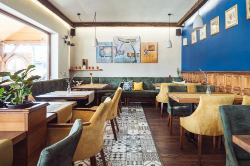 a restaurant with couches and tables and a blue wall at Hotel Vineyard Inn - Szőlőskert in Nagykanizsa