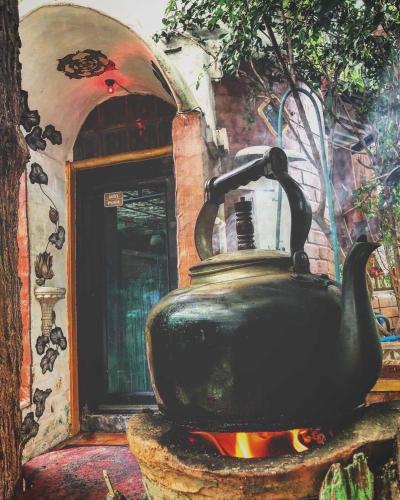a large black kettle sitting on top of a stove at Good Life Dacha Wellness Homestay in Pai