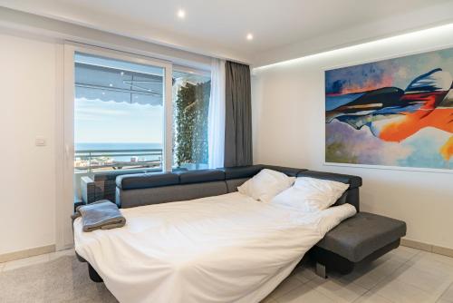 a bedroom with a bed and a large window at Frontière Monaco, Terrasse, Vue Mer, Parking - AB in Beausoleil