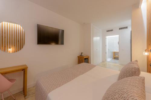 a bedroom with a bed and a tv on the wall at Hotel Boutique Sibarys - Adults Recommended in Nerja