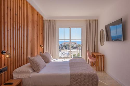 a hotel room with a bed and a large window at Hotel Boutique Sibarys - Adults Recommended in Nerja