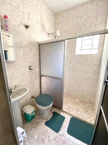 un bagno con doccia, WC e lavandino di Casa de Temporada Ubirajara a Aparecida