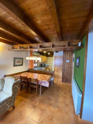a kitchen and dining room with a wooden ceiling at Aparthotel Areu in Areu