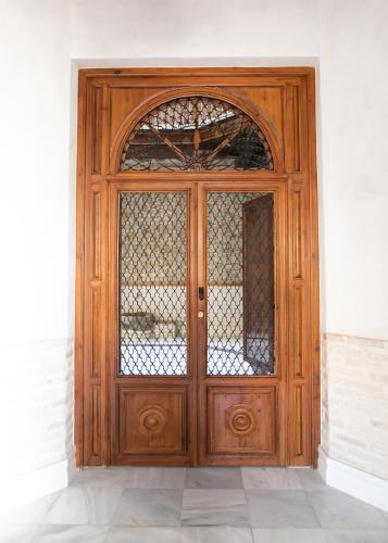a wooden door in a building with a window at innCádizPalacio Conde Casa-Brunet in Cádiz