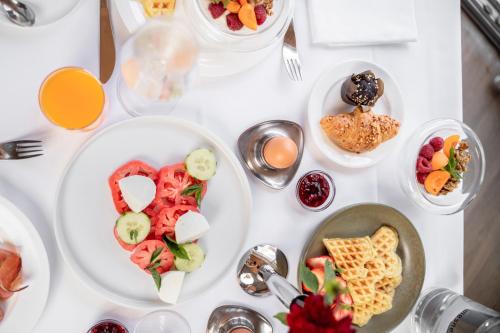 a white table with plates of food on it at Hotel WH - Wiesnerhof in Vipiteno
