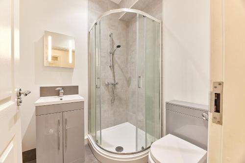 a bathroom with a shower and a toilet and a sink at Barnes boutique apartment in Sunderland