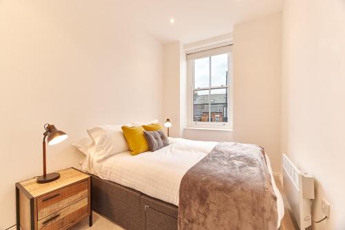 um quarto branco com uma cama e uma janela em Barnes boutique apartment em Sunderland