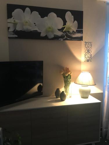 a living room with a tv and a lamp on a dresser at Casa Perla in Lavagna
