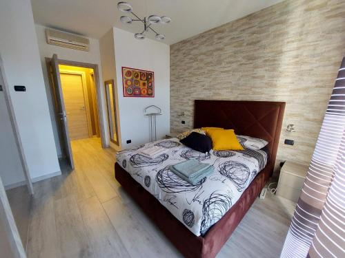 - une chambre avec un grand lit et un mur en briques dans l'établissement Luminoso appartamento a pochi minuti da Duomo e Fiera, à Milan