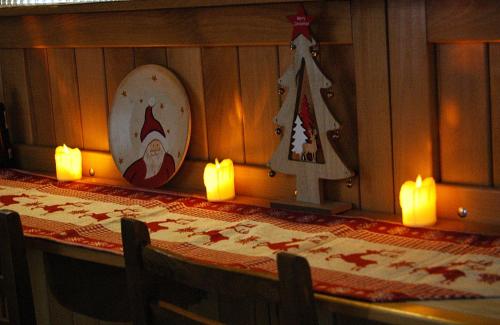 a table with candles and christmas decorations on the wall at Badishi Guesthouse in Mestia