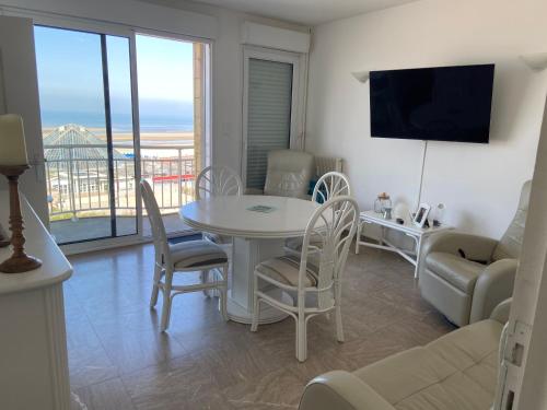 un salon avec une table, des chaises et un canapé dans l'établissement Marina, à Le Touquet-Paris-Plage