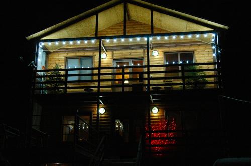 a house with lights on the front of it at night at Badishi Guesthouse in Mestia