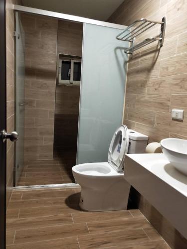 a bathroom with a toilet and a sink and a shower at Xinyuanbao Shangshi Homestay in Donggang