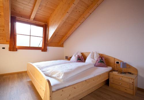 a bedroom with a large bed with a window at Gasserhof Aicha in Natz-Schabs