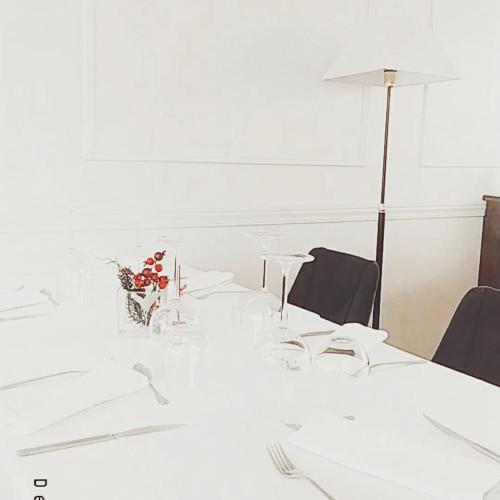a white table with chairs and a vase of flowers at Hotel Puerta Ciudad Rodrigo in Ciudad-Rodrigo