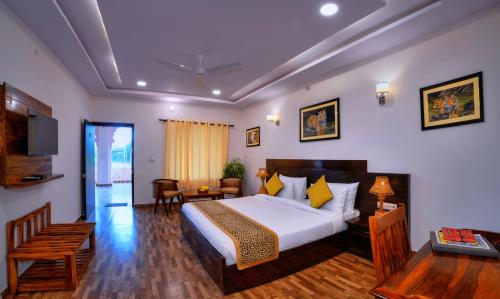 a bedroom with a bed and a desk and a television at Ranthambore Bagh Palace in Sawāi Mādhopur