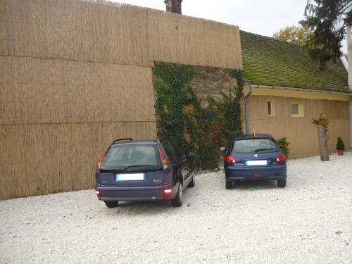 two cars parked in a parking lot next to a building at Szent István Panzió in Hódmezővásárhely