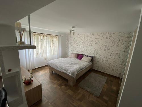 a small bedroom with a bed and a wall at Garsoniera deosebita intr-o zona linistita Straja-Lupeni in Lupeni