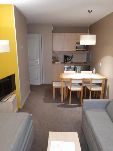 un salon avec une table et une cuisine dans l'établissement Appartements 4 à 5 personnes - Val d'Europe proche Disneyland, à Serris