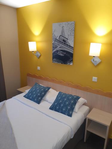 een slaapkamer met een bed met twee blauwe kussens bij Appartements 4 à 5 personnes - Val d'Europe proche Disneyland in Serris