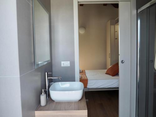 a small bathroom with a sink and a bed at I Giardini Di Zelda in Policoro