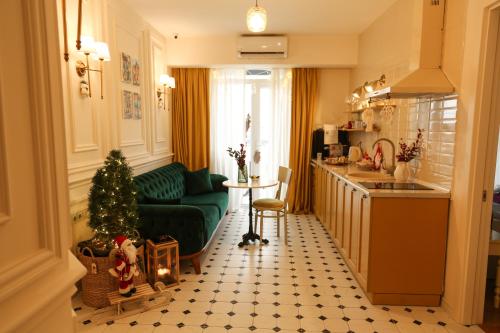 a living room with a green couch and a christmas tree at Boutique Apartment - Signature in Kutaisi