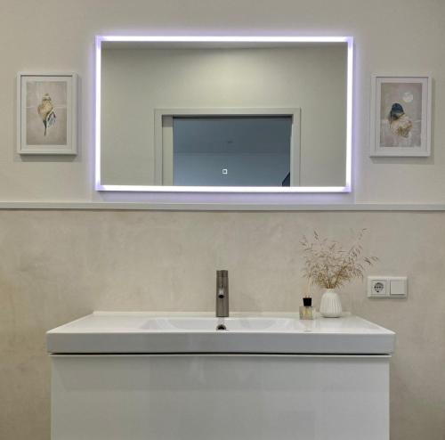 a bathroom with a white sink and a mirror at Appartement Mond in Senftenberg