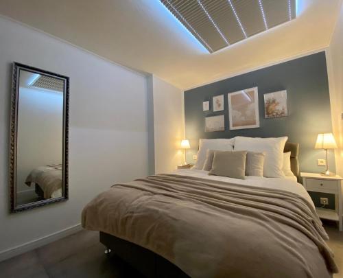 a bedroom with a large bed and a mirror at Appartement Mond in Senftenberg