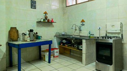 a small kitchen with a stove and a sink at Hostel Marthi Itamambuca in Ubatuba