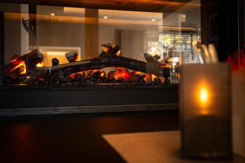 a fire in a fireplace with a candle next to it at Ringhotel Appelbaum Gütersloh in Gütersloh