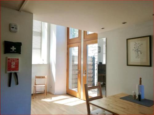- un salon avec une porte en bois et une chaise dans l'établissement Central Mezzanine Apartment in Historic School, à Édimbourg