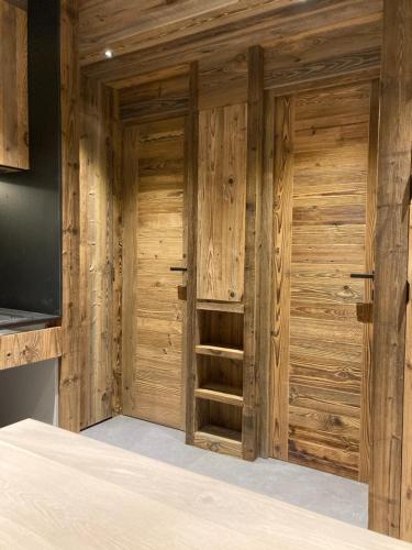 a room with wooden doors and a television at Appartement 4 à 5 personnes in Val dʼIsère