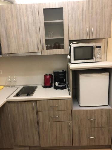 a small kitchen with a microwave and a stove at Mi Casa apartment in Veliko Tŭrnovo