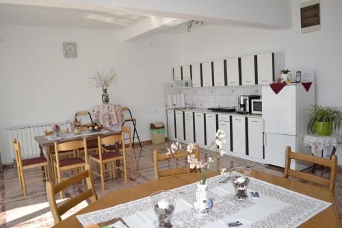 a kitchen and dining room with a table and chairs at Guest House Morski val in Bar