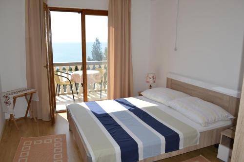 a bedroom with a bed with a view of the ocean at Guest House Morski val in Bar