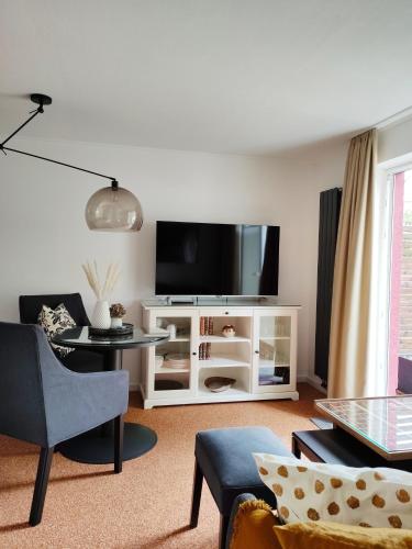 Lancken-GranitzにあるAppartement RügenZeitのリビングルーム(白いキャビネット、薄型テレビ付)