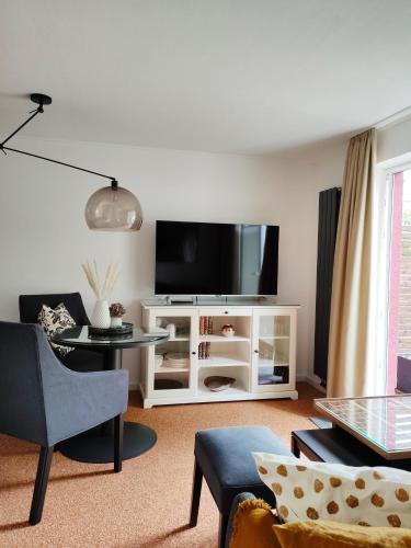 a living room with a flat screen tv on a white cabinet at Appartement RügenZeit in Lancken-Granitz