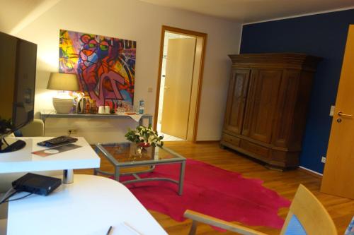 a living room with a table and a red rug at Hotel & Restaurant Venner Moor in Senden